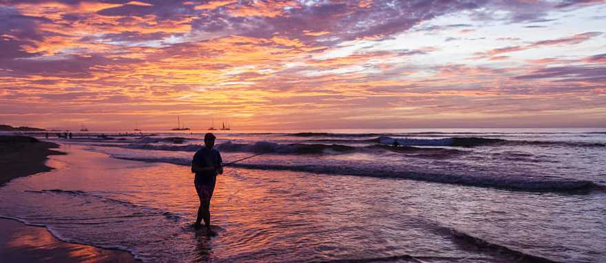 Fisherman silhouetted against the setting sun on Playa Tamarindo in Costa Rica Fisherman silhouetted against the setting sun on Playa Tamarindo in Costa Rica