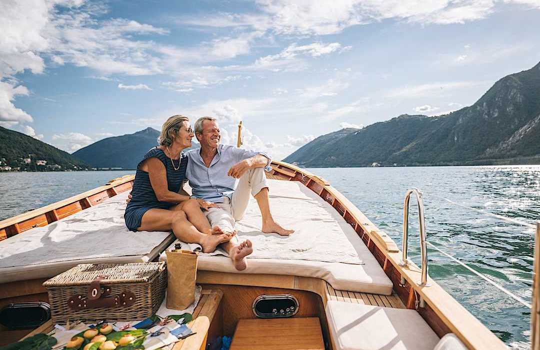 Luxury senior couple cruising on a private boat on a lake in Switzerland
