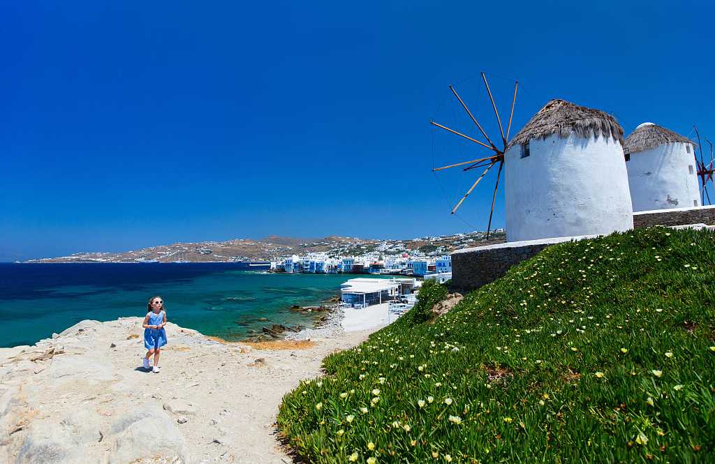 Girl and windmills in Mykonos