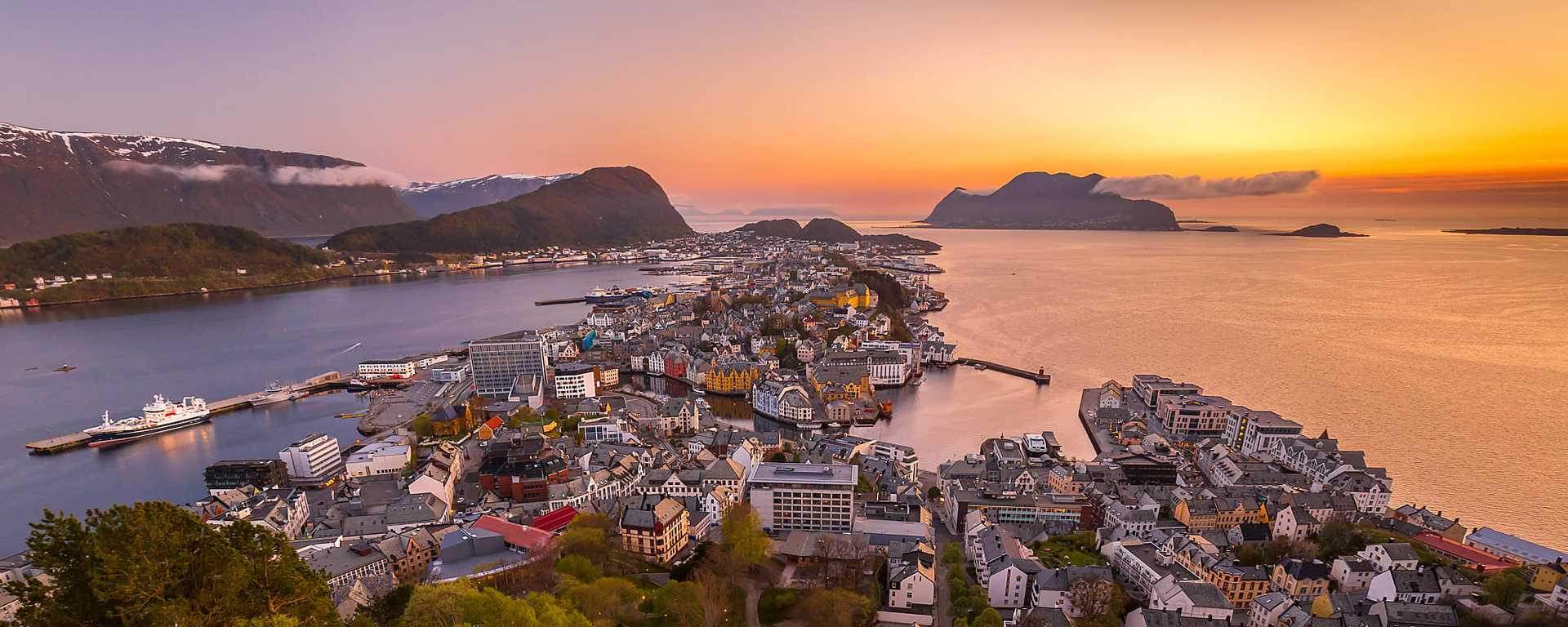 Sun setting on the horizon in Alesund, Norway