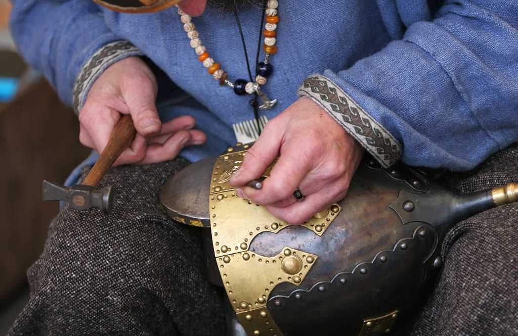 metal craftsman making a medieval soldiers helmet armor the old fashioned way