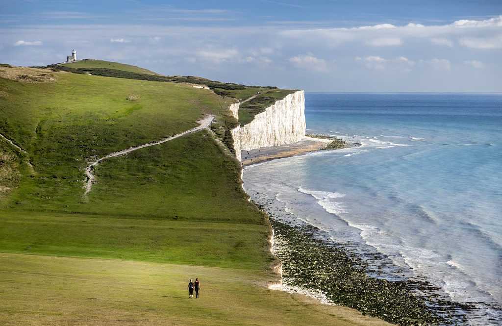 Couple walking on the Seven Sisters Chalk Cliffs on the South Coast of England