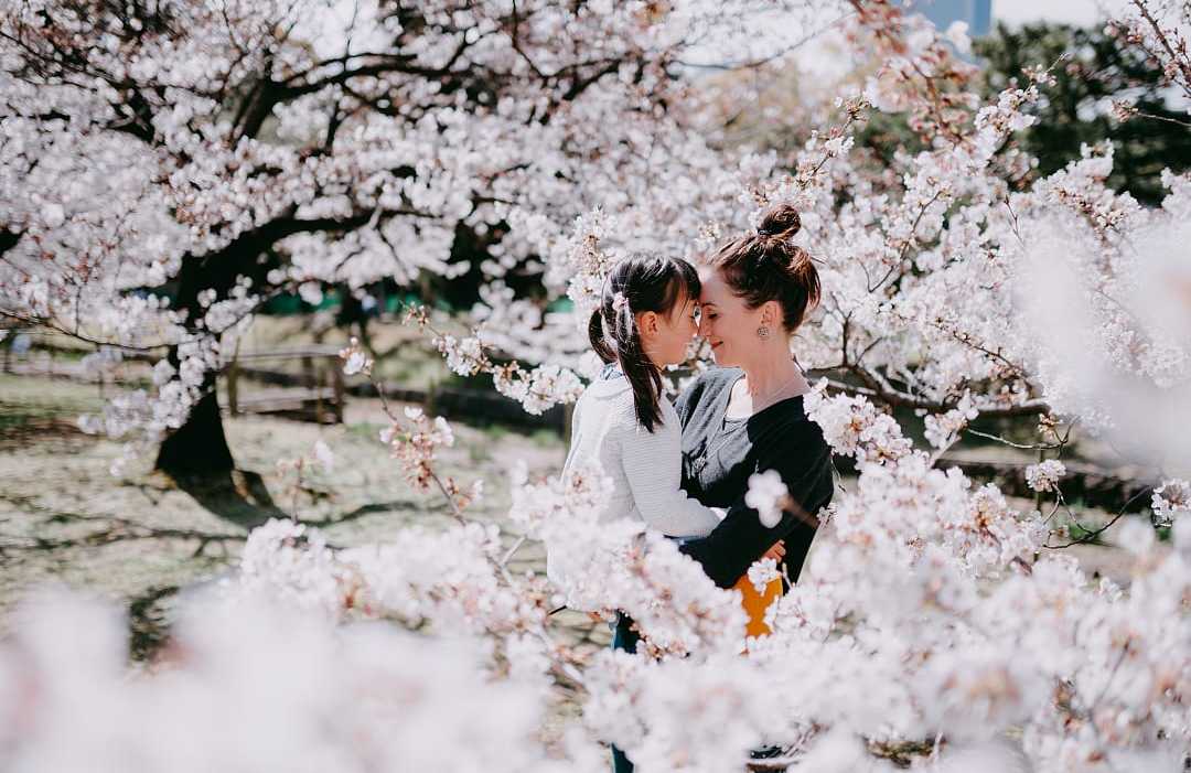 Mother and daughter sharing a moment amongst the cherry blossoms in Tokyo, Japan