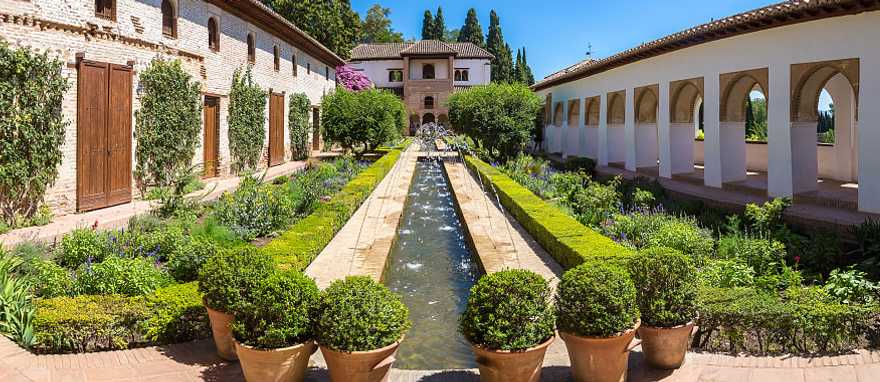 Garden and bell tower at Alhambra Palace in Granada in a beautiful summer day, Spain