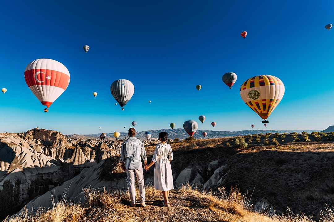 Couple watching the hot air balloons launch in Cappadocia, Turkey