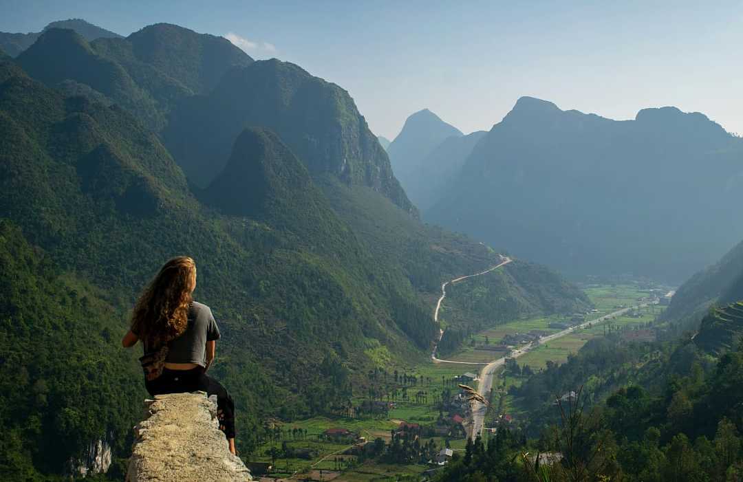 Woman sitting at an overlook along the Sky Path in Ha Giang, Vietnam