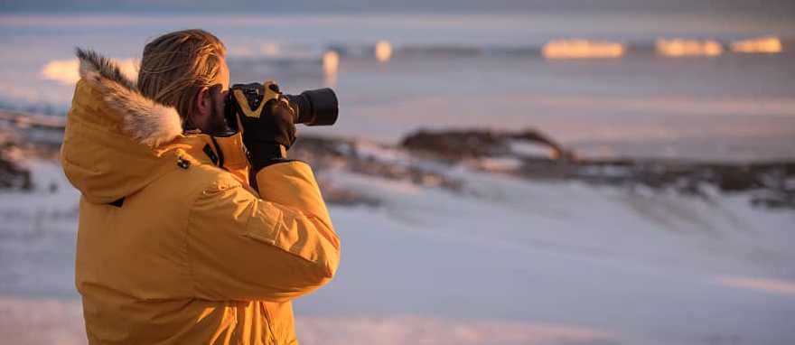 A traveler takes photos during an expedition to Antarctica A traveler takes photos during an expedition to Antarctica