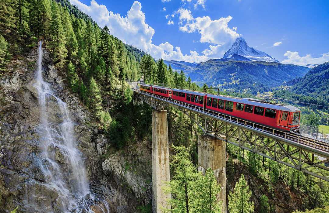 A red train crossing a high mountain bridge in Switzerland. A red train crossing a high mountain bridge in Switzerland.