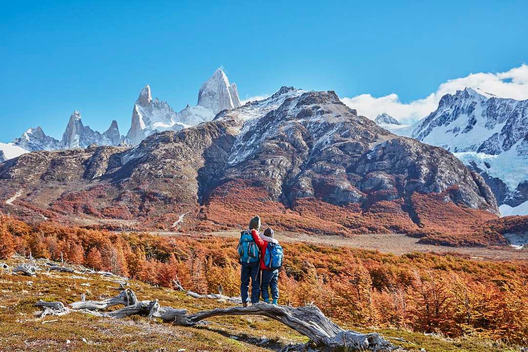 Brothers admiring the snowy peaks of Mount Fitz Roy, Patagonia, Argentina, during autumn