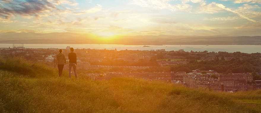 Couple enjoying cityscape at sunset, Edinburgh, Scotland, UK