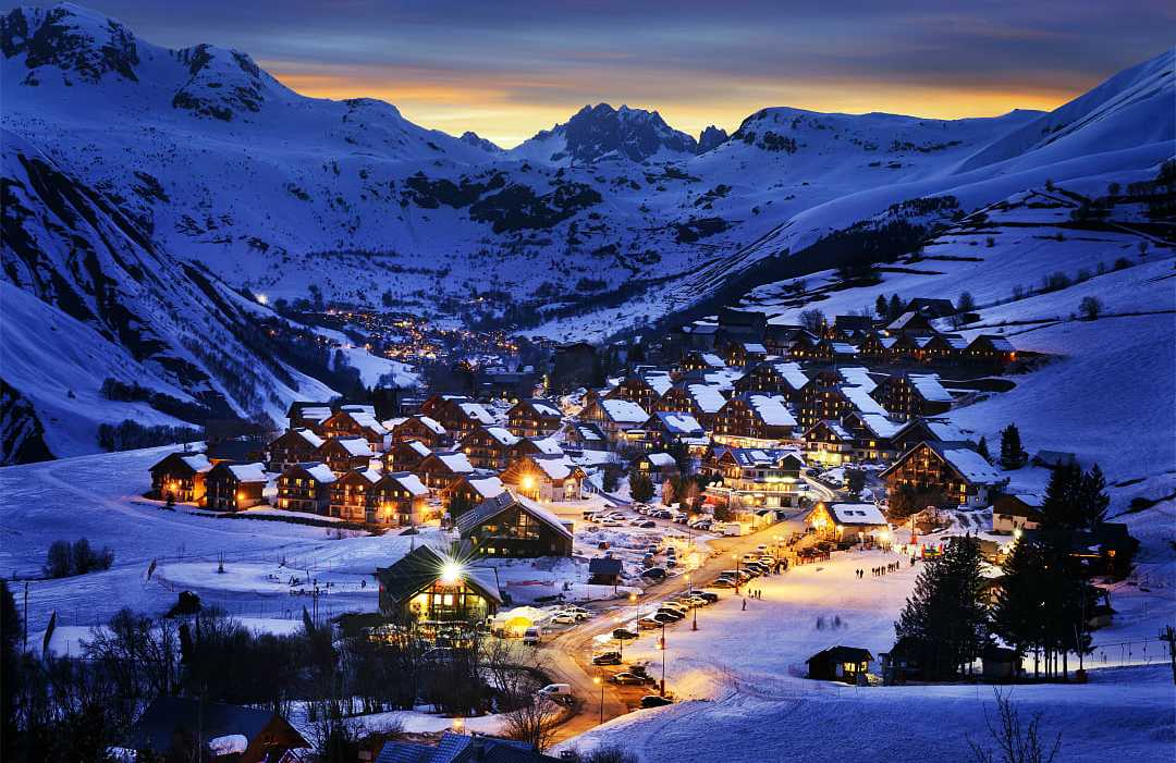Cozy alpine village nestled in the French Alps, covered in snow.