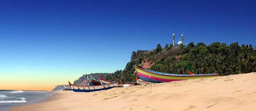 Colorful fishermen boats on beach in front of Varkala south cliff in Kerala, India Colorful fishermen boats on beach in front of Varkala south cliff in Kerala, India