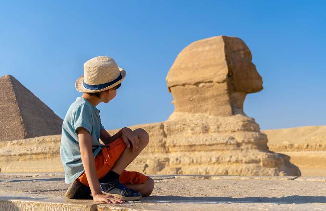 Young boy looking at the Great Sphinx of Giza in Egypt