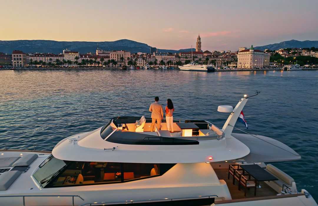 Couple on a luxury yacht admiring the Split skyline during dusk in Croatia