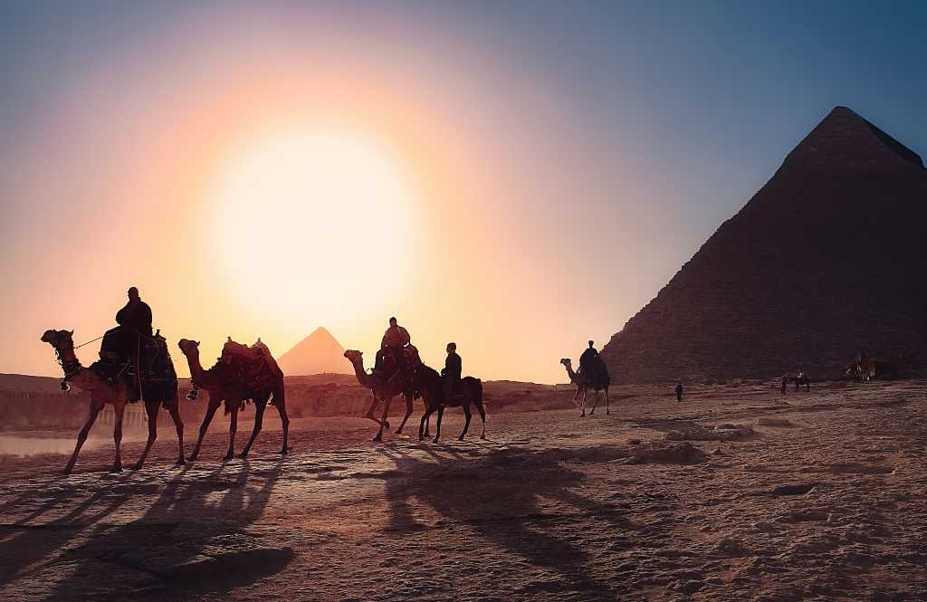 People riding camels at the Pyramids at Giza, Egypt