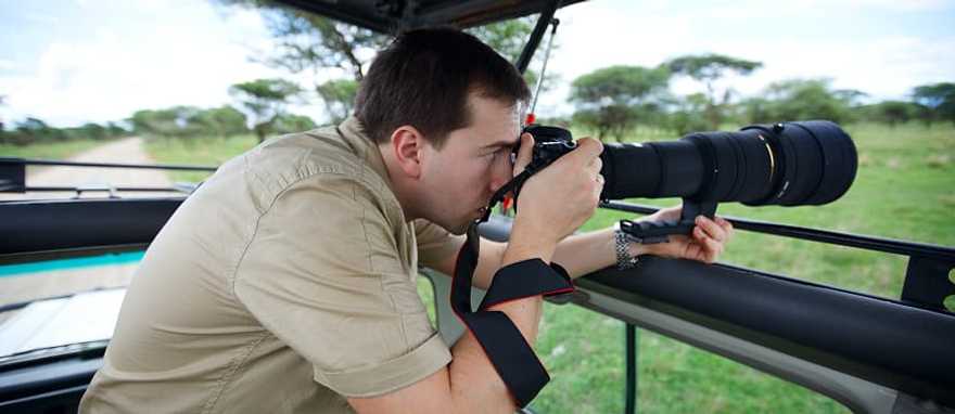 Photographer on game drive in the African savannah Photographer on game drive in the African savannah