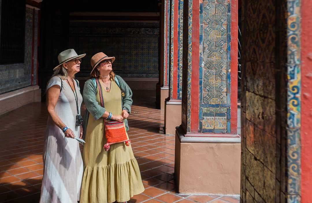 Senior travelers exploring the colorful tile work of the Convent of Santo Domingo in Lima, Peru