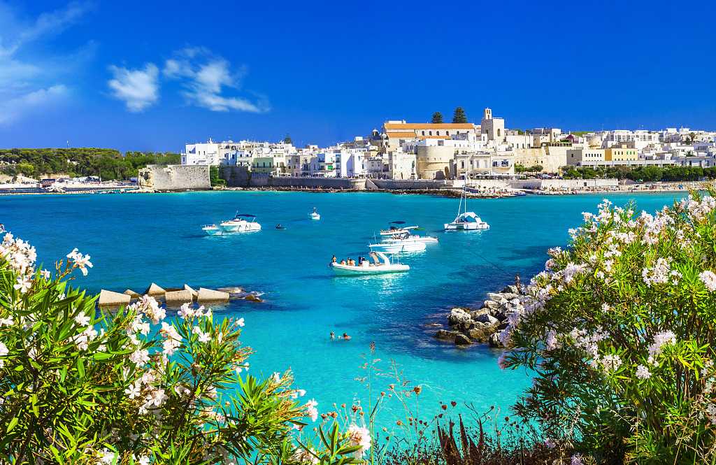 Boats in the crystal blue waters of Otranto in Puglia, Italy.