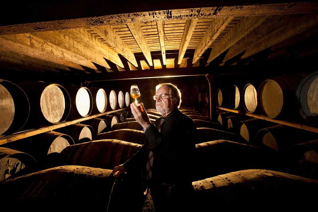 Worker testing whisky in distillery