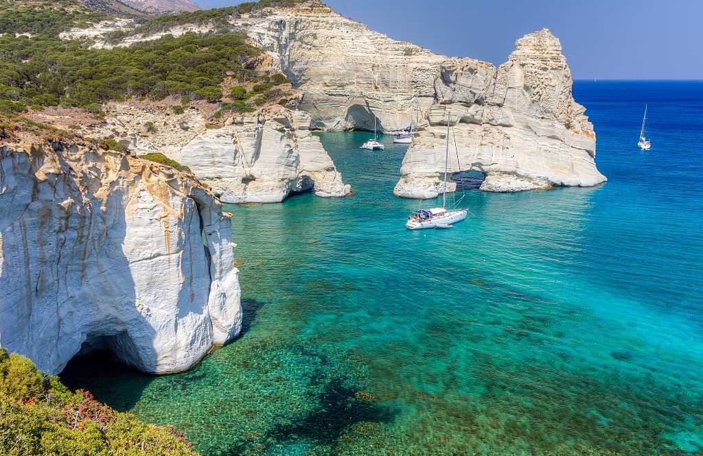 Cliffiside waters with boats at Kleftiko Beach in Milos, Greece